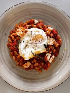 Una foto de Fessolets con tomate y queso feta al horno con huevo frito