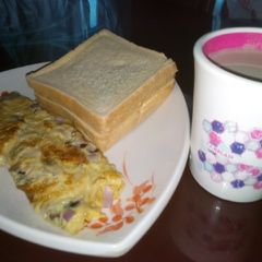 A picture of Fried egg with bread and tea.