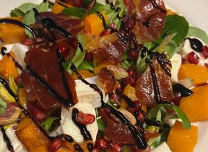Foto principal de Ensalada de Calabaza Otoñal con Crujiente de Jamón Serrano, Granada y Rulo de Cabra