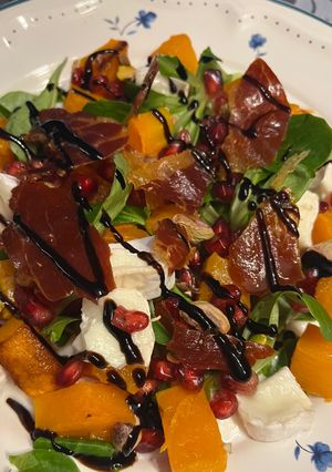 Una foto de Ensalada de Calabaza Otoñal con Crujiente de Jamón Serrano, Granada y Rulo de Cabra