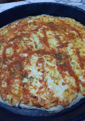 Una foto de Pizza básica con salsa y mantecoso