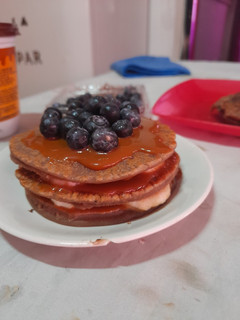 Una foto de Pancakes de chocolate con dulce de leche, banana y arándanos