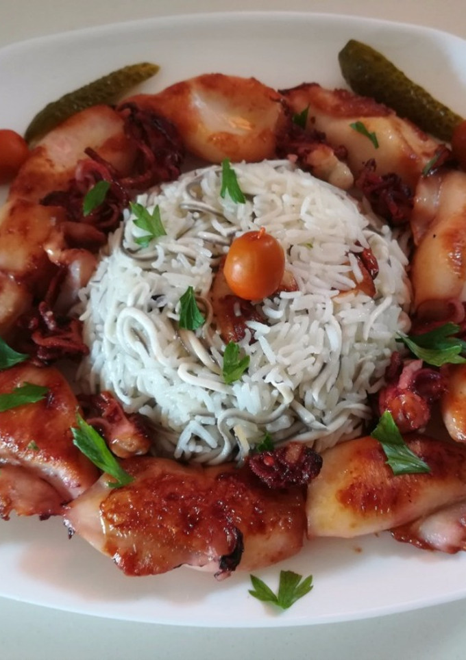 Una foto de Timbal de arroz con gulas y calamares
