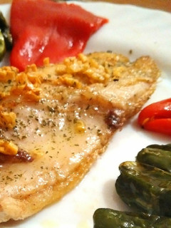 Una foto de Lubina plancha con crujiente de ajo padrón y piquillo