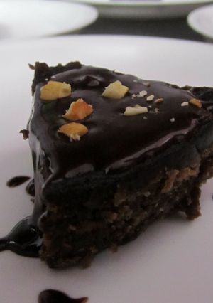 A picture of Chocolate fudge with Chocolate sauce and nuts.