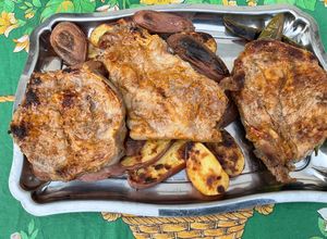 Une photo de Côtes de porc grillées marinées sauce tomate aux pommes de terre et piments verts