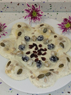 Una foto de Pasta mezzelune con gorgonzola y nueces con crema de albahaca y frutos secos