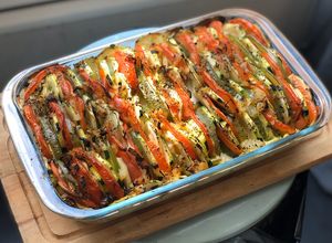 Une photo de Tian de courgette tomate poivron & mozzarella disposé sur un riz aux oignons caramélisés