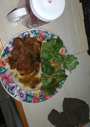 A picture of Smothered pork chops with mash potato.