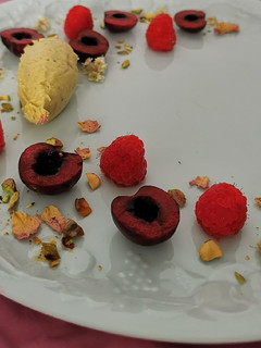 Una foto de Quenelle de mascarpone y pistache con frutos rojos