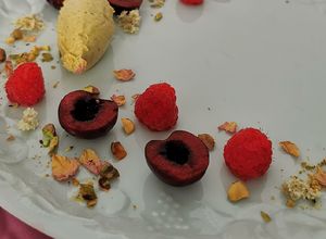 Una foto de Quenelle de mascarpone y pistache con frutos rojos