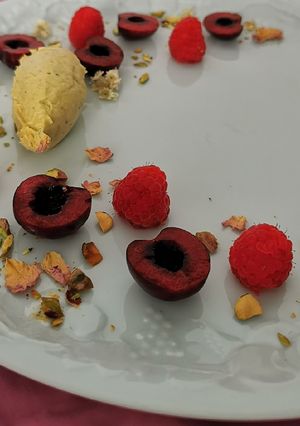 Una foto de Quenelle de mascarpone y pistache con frutos rojos