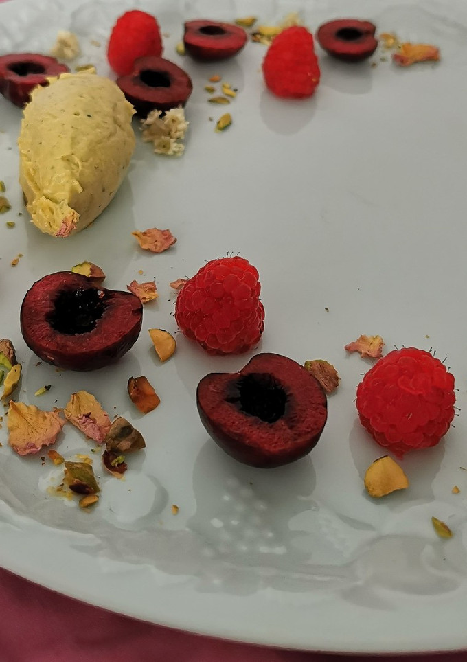 Una foto de Quenelle de mascarpone y pistache con frutos rojos