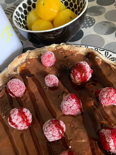 Una foto de Tortita de quinoa con crema de chocolate fit y frambuesas congeladas