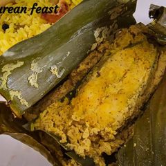 A picture of Bhetki machher paturi/ Barramundi cooked in banana leaves.