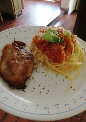 Una foto de Espaguetis en salsa pomodoro y bondiola de cerdo