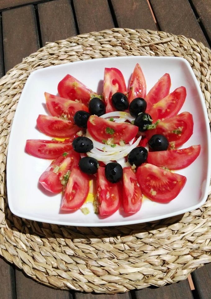 Una foto de Ensalada de tomate, pimientos asados, cebolla y aceitunas