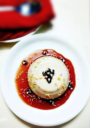 A picture of Vanilla Panna cotta in Strawberry Sauce.