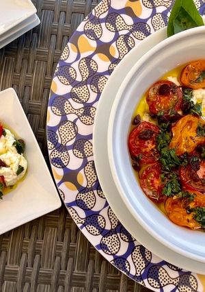 Une photo de Tomates cerises rôties sur un lit de burrata