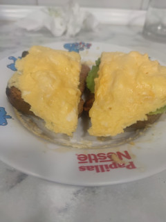 Una foto de Tostadas con huevos revueltos con queso y aguacate