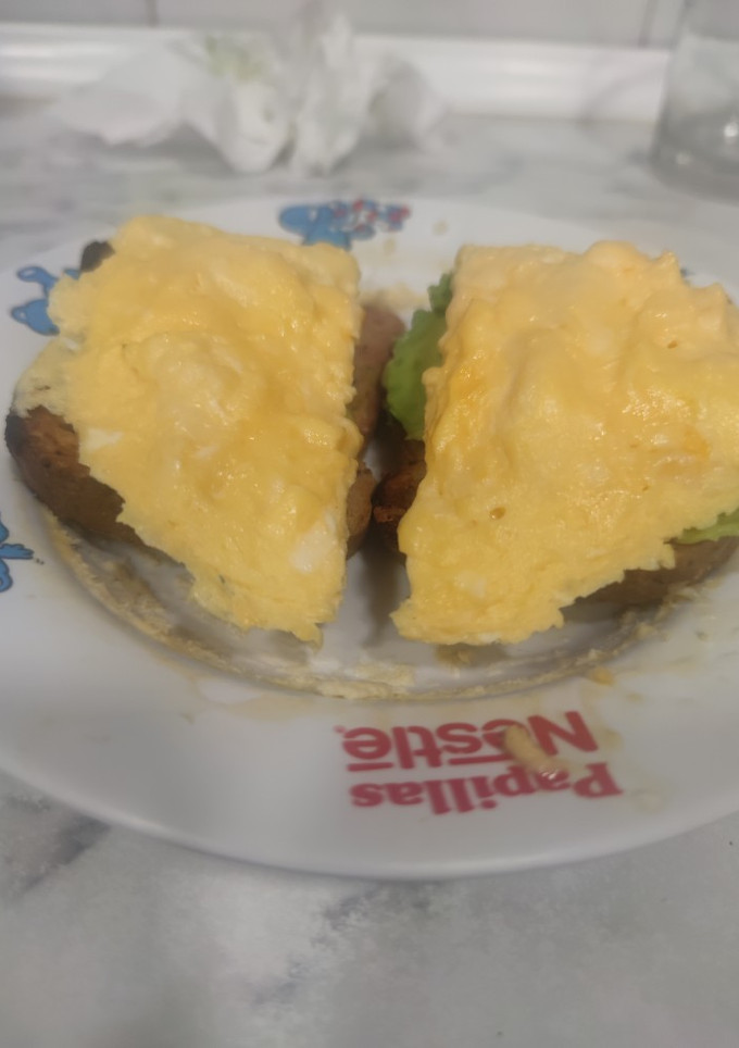 Una foto de Tostadas con huevos revueltos con queso y aguacate
