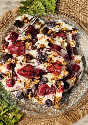 Una foto de 🍓🫐🫙Bark helada de yogur griego, frutos rojos y avena con hilos de chocolate 🫙🫐🍓