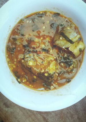 A picture of Okra soup with ice fish and pumpkin leaf.