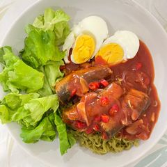A picture of Spicy canned mackerel in tomato sauce on green noodles.