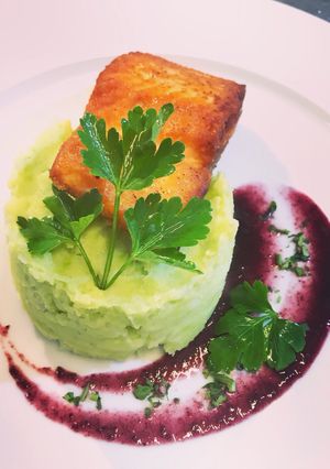 Una foto de Salmón a la plancha sobre puré de Habas y salsa de arándano