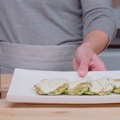 A picture of Zucchini fritters with yogurt sauce.