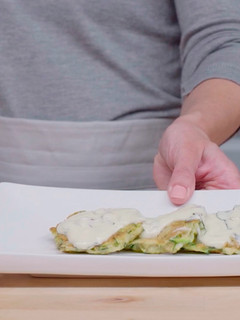 A picture of Zucchini fritters with yogurt sauce.
