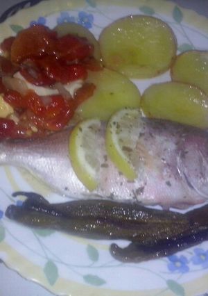 Una foto de Brecas al horno con cama de patatas y tomate