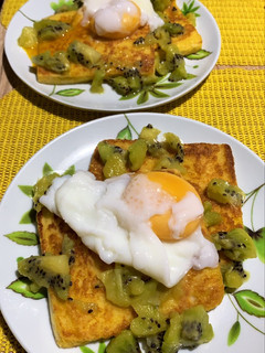 A picture of Breakfast toast with poached egg and kiwi.