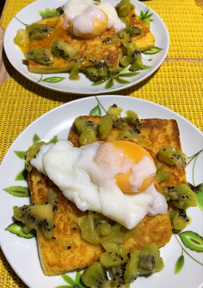 A picture of Breakfast toast with poached egg and kiwi.