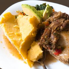 A picture of Matoke and boiled beef(ossubuco) served with veggies.