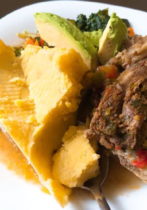 A picture of Matoke and boiled beef(ossubuco) served with veggies.