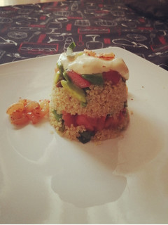 Una foto de Timbal de quinoa, palta, tomate y camarones al merkén