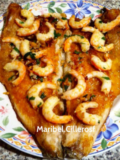 Una foto de Lubina a la plancha con gambas al ajillo