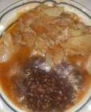 Bistec de puerco con cebolla y papas en salsa de jitomate