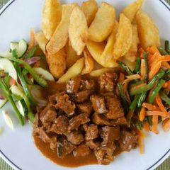 A picture of Potato wedges, Beef, Fried French beans and carrots.
