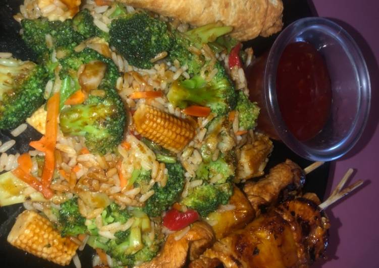 Teriyaki chicken and pineapple skewers with fried rice and veggies and eggs rolls