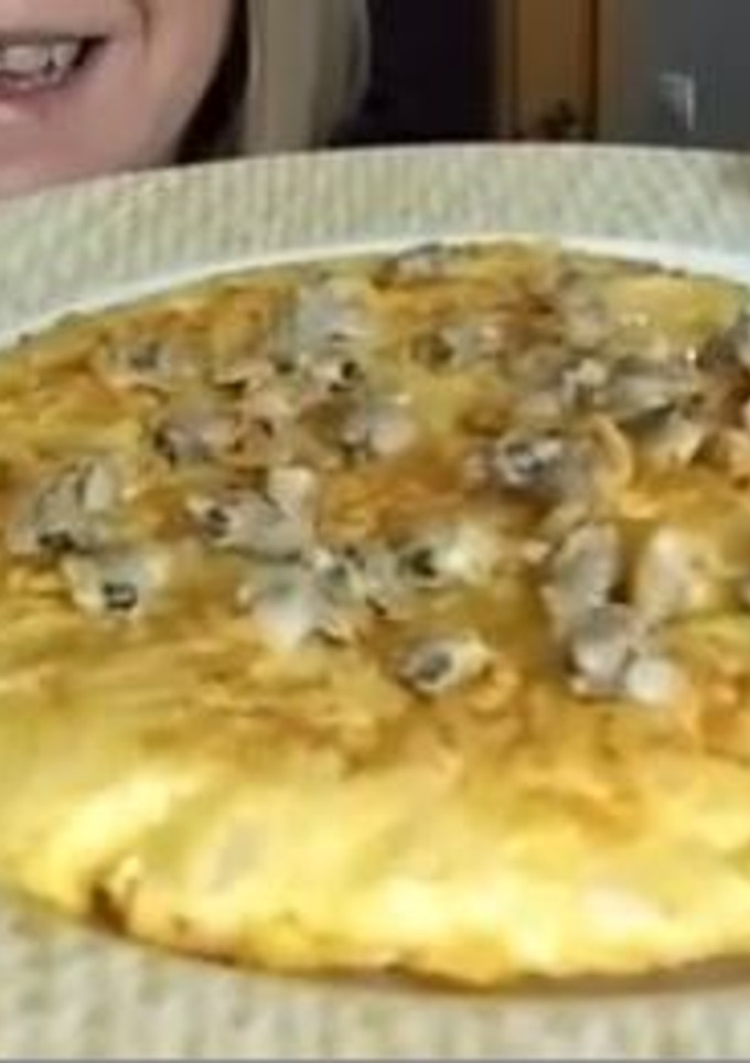 Una foto de Tortilla de bacalao con decoración de berberechos
