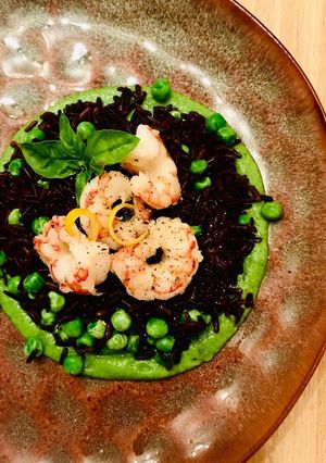 Foto di Riso venere con gamberi e piselli su crema di zucchine