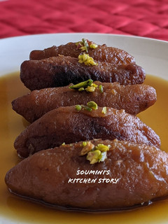 A picture of Raanga Aalur Roshomoti (Sweet Potato dumplings in jaggery syrup).
