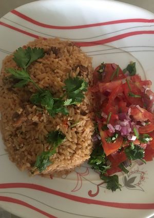 A picture of Beef pilau served with kachumbari.