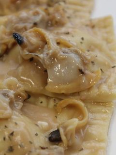 Una foto de Raviolis de gamba con almejas en salsa verde