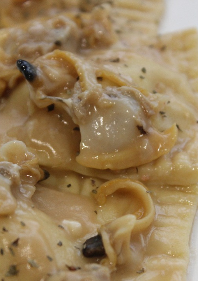 Una foto de Raviolis de gamba con almejas en salsa verde