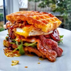 A picture of Southern Chicken Waffle Burger With Egg & Maple Glazed Bacon.