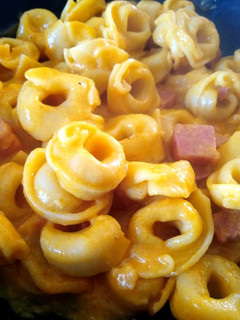 Una foto de Tortellini rellenos de queso con salsa de curry y mortadela