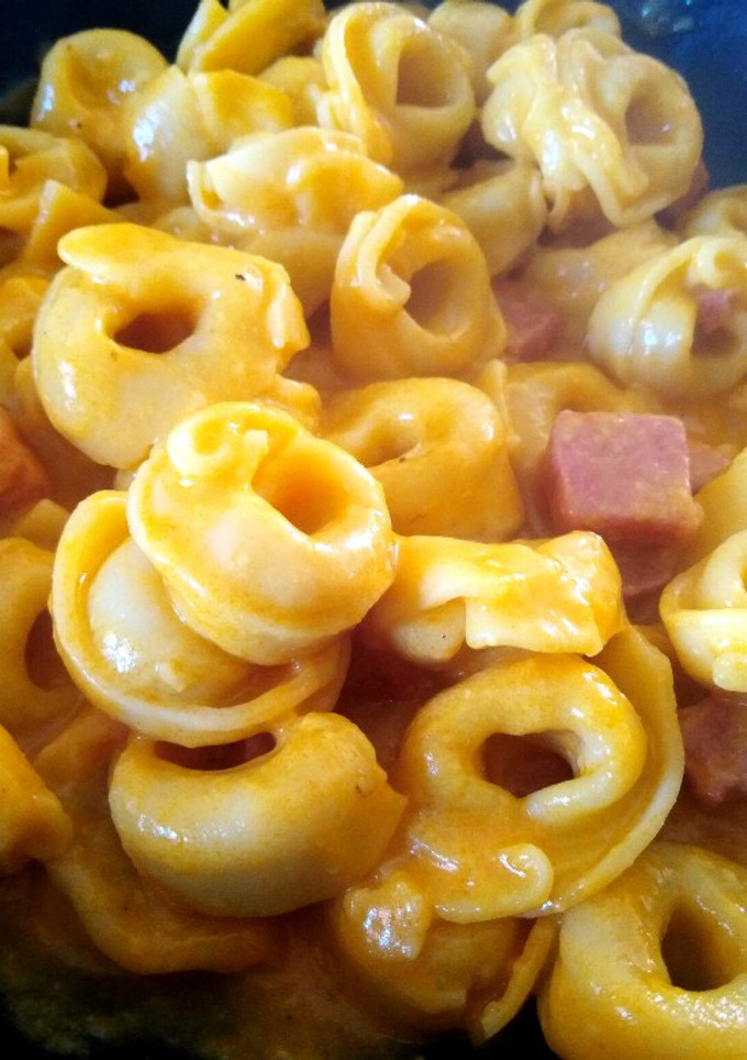 Una foto de Tortellini rellenos de queso con salsa de curry y mortadela